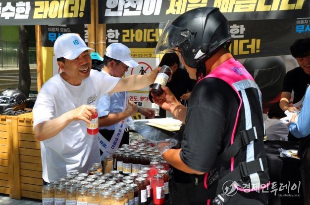 근로복지공단 박종길 이사장(왼쪽)이 지난 7월 서울 역삼역 인근에서 배달라이더들에게 시원한 음료를 나누어 주면서 고용·산재보험 거리 홍보를 진행했다.